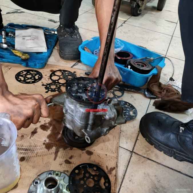 teknisi membongkar kompresor ac mobil macet di bengkel ac mobil jakarta barat sejuk ac joglo